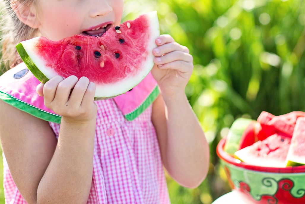 child outside eating watermelon